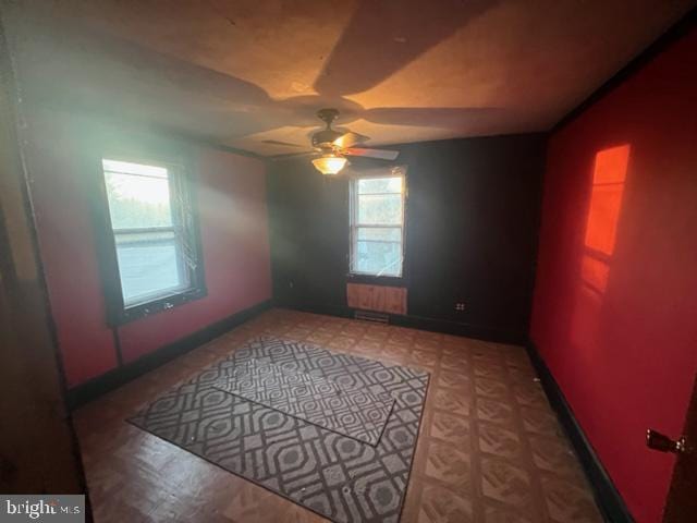 unfurnished room with baseboards and a ceiling fan