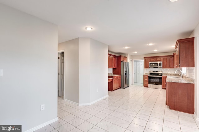 kitchen featuring a sink, decorative backsplash, baseboards, and stainless steel appliances