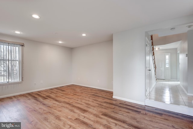 unfurnished room with recessed lighting, baseboards, and light wood finished floors