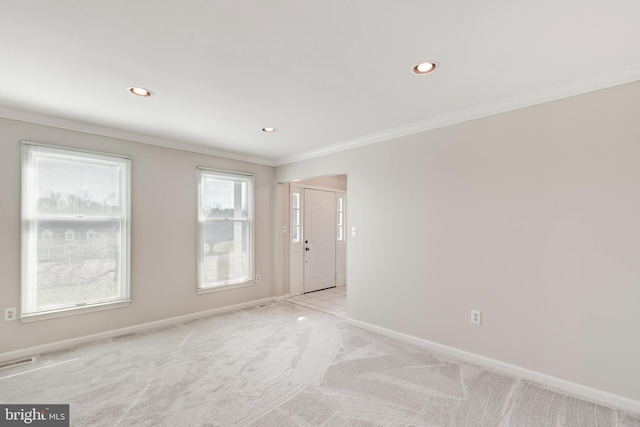 spare room with visible vents, crown molding, baseboards, light colored carpet, and recessed lighting