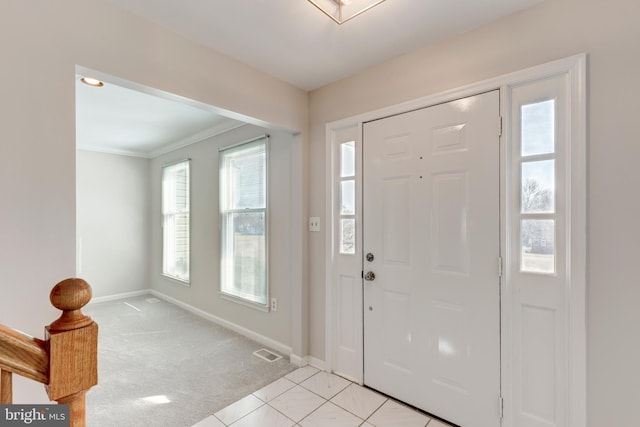 entryway with visible vents, light carpet, baseboards, and light tile patterned flooring