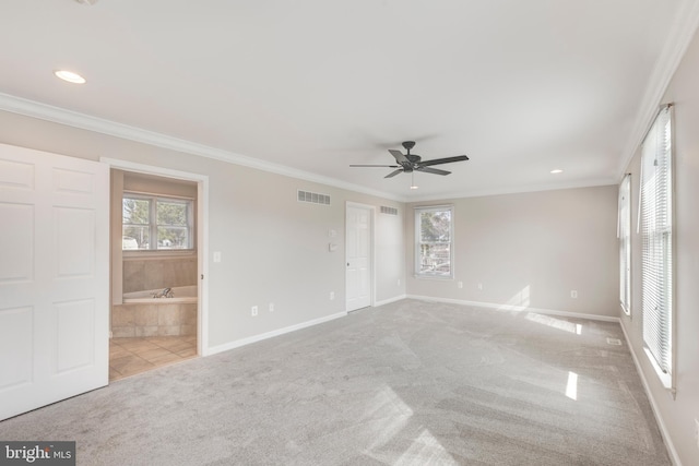 carpeted empty room with a ceiling fan, visible vents, baseboards, and ornamental molding