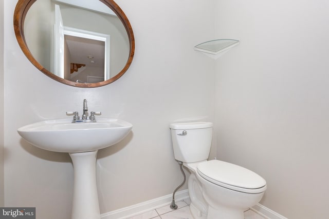 half bathroom with toilet and baseboards