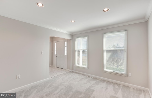 carpeted spare room with visible vents, recessed lighting, crown molding, and baseboards