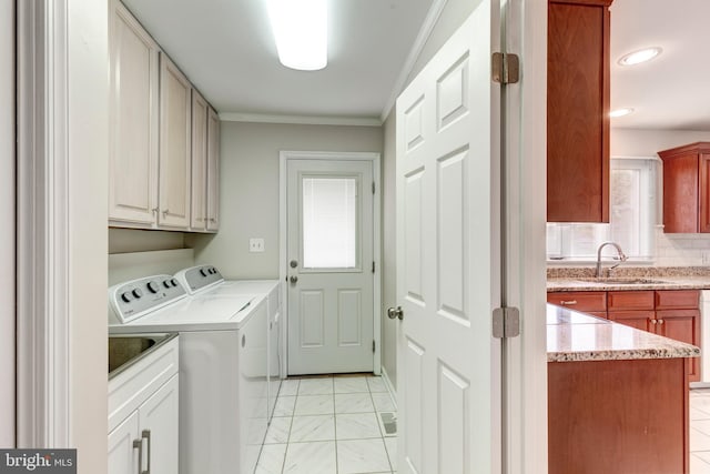 laundry area with a sink, cabinet space, independent washer and dryer, and ornamental molding