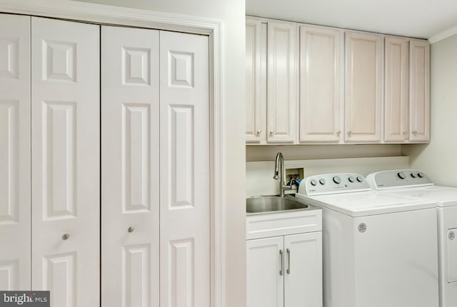 clothes washing area featuring cabinet space, washer and dryer, and a sink