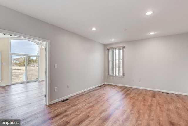 spare room with recessed lighting, visible vents, light wood finished floors, and baseboards