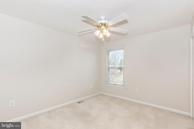 empty room featuring visible vents, a ceiling fan, baseboards, and light carpet