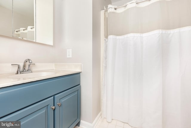 full bath featuring curtained shower, baseboards, vanity, and tile patterned flooring