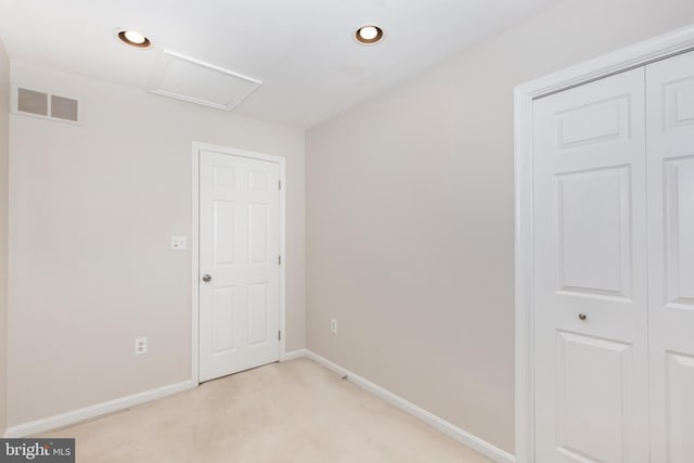 empty room with visible vents, recessed lighting, baseboards, light colored carpet, and attic access