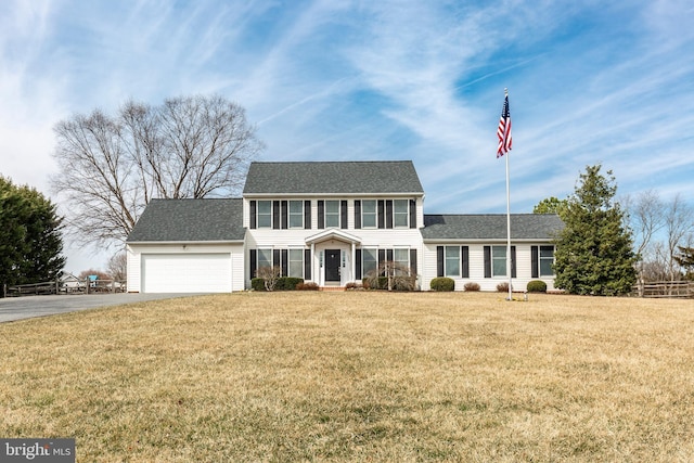 colonial-style house featuring a front lawn, a garage, and driveway