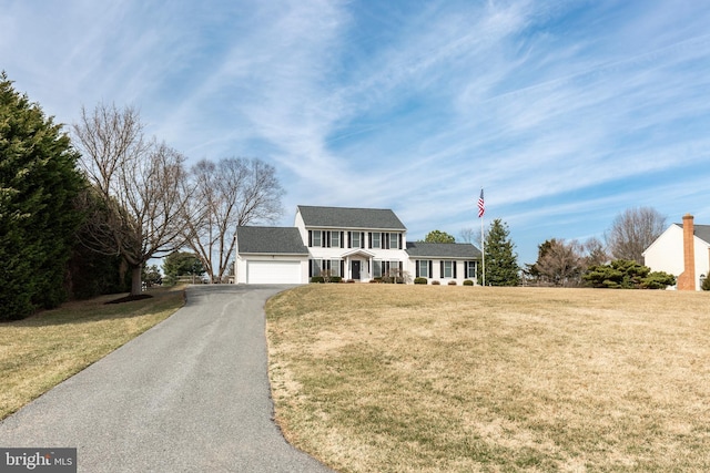 view of front facade with a front yard, a garage, and driveway