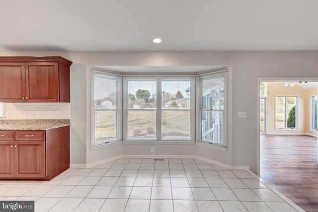 unfurnished dining area with light tile patterned flooring, recessed lighting, and baseboards