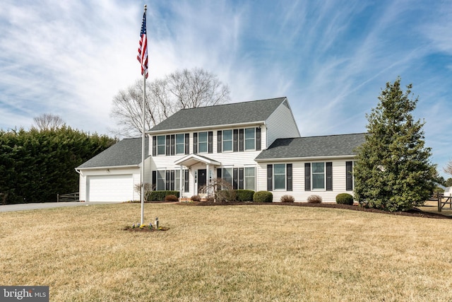 colonial house with driveway, a front lawn, a garage, and roof with shingles