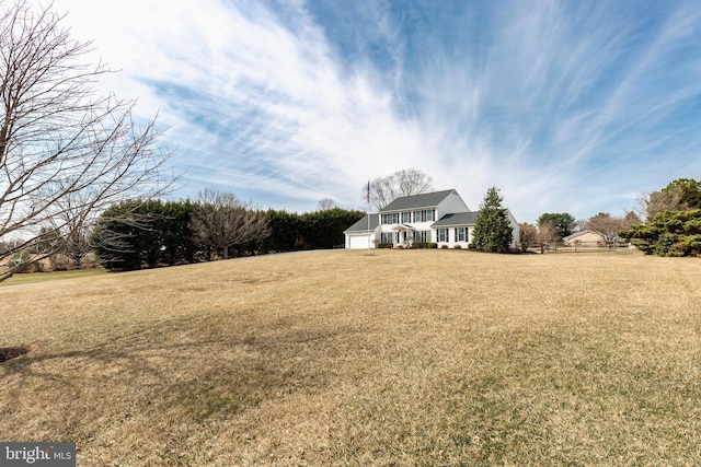 view of yard featuring an attached garage and fence