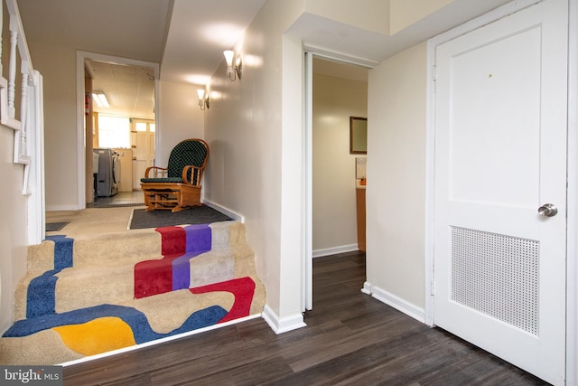 interior space with wood finished floors, baseboards, and washing machine and clothes dryer