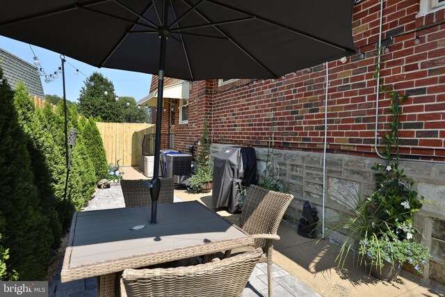 view of patio with central AC unit and fence