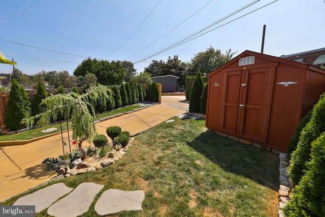 view of yard with a patio, a storage shed, an outdoor structure, and fence