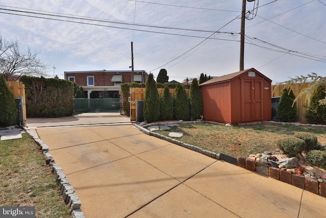 view of front of home with an outbuilding, a storage unit, and fence