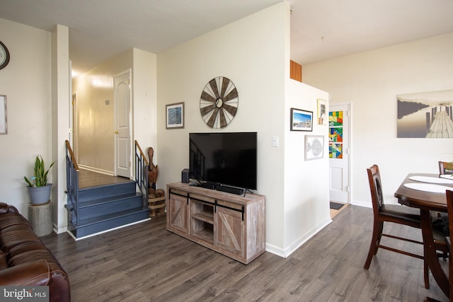 living area featuring stairway, baseboards, and wood finished floors