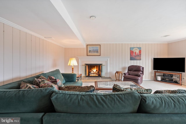 living room featuring a lit fireplace, crown molding, and carpet