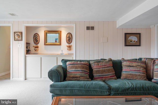 carpeted living room featuring visible vents and crown molding