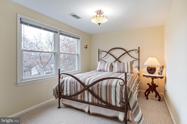 carpeted bedroom featuring visible vents and baseboards