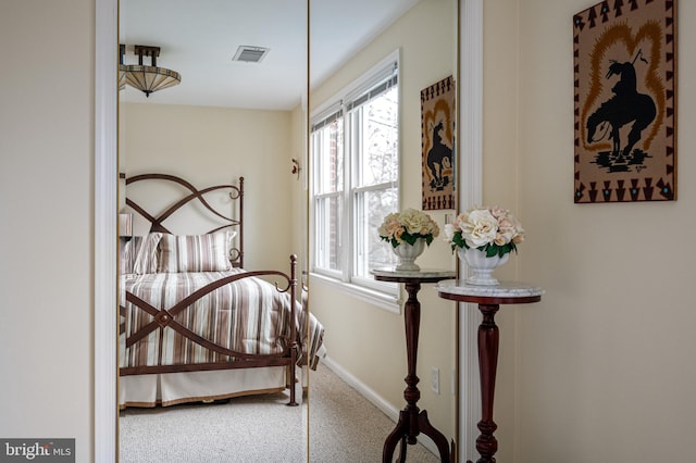 carpeted bedroom featuring visible vents and baseboards