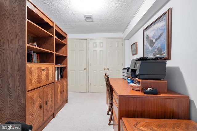 office space with light colored carpet, visible vents, and a textured ceiling