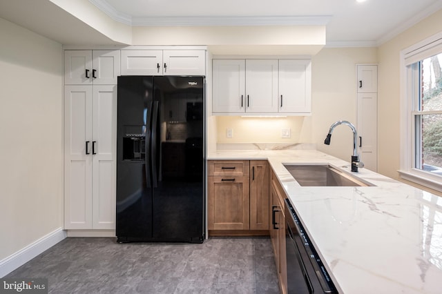 kitchen with a sink, light stone countertops, black appliances, and ornamental molding