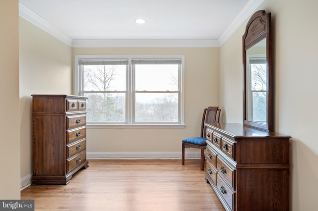 living area with crown molding, baseboards, and light wood finished floors