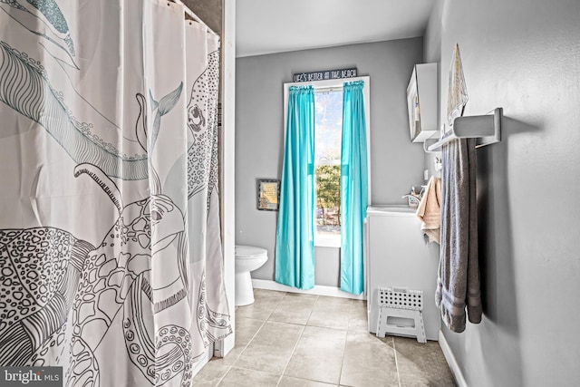 bathroom featuring tile patterned flooring, toilet, and baseboards