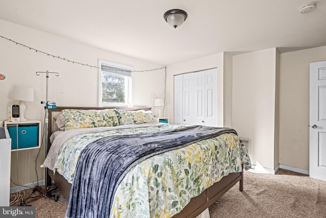 carpeted bedroom featuring a closet and baseboards