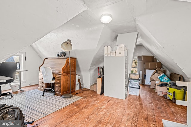 office area with lofted ceiling, plenty of natural light, and hardwood / wood-style floors