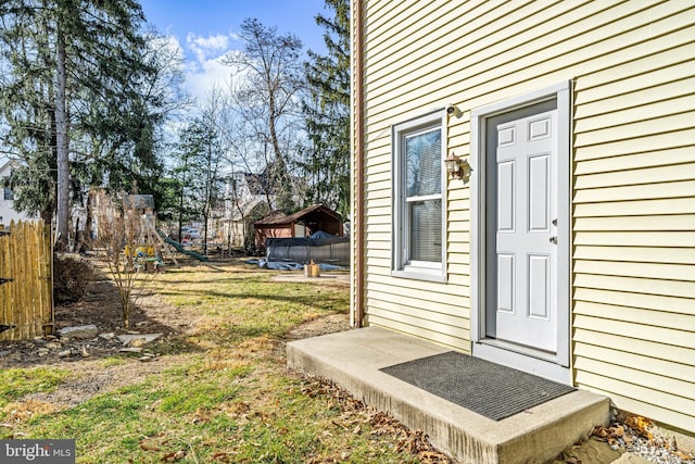 entrance to property with a yard and fence