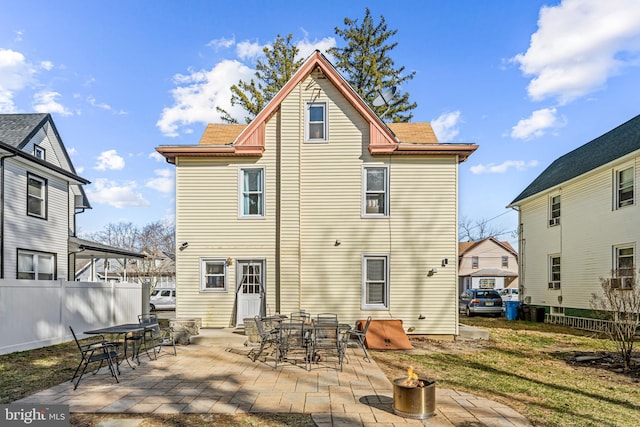 back of house featuring roof with shingles, a patio, and fence