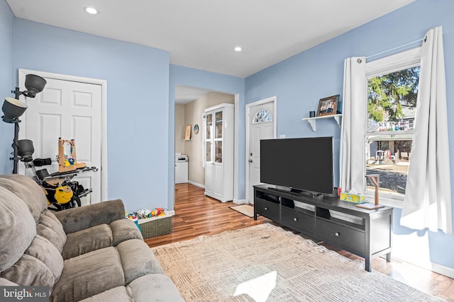 living area with recessed lighting, baseboards, and wood finished floors