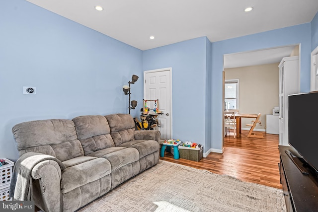 living room featuring recessed lighting, light wood-type flooring, and baseboards