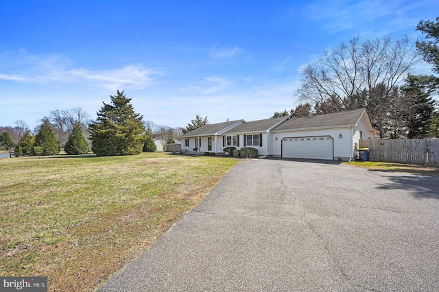 ranch-style home featuring aphalt driveway, an attached garage, a front yard, and fence