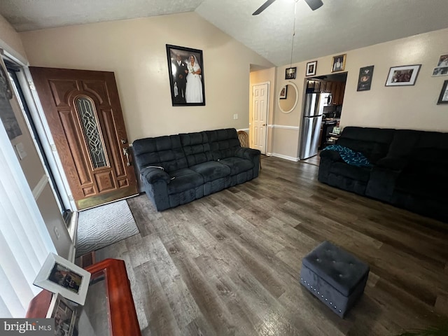 living area with wood finished floors, a ceiling fan, and lofted ceiling