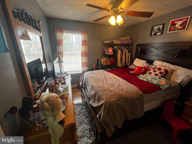 bedroom featuring a textured ceiling, wood finished floors, and a ceiling fan