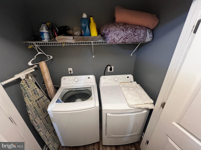 clothes washing area with washing machine and clothes dryer, laundry area, and wood finished floors