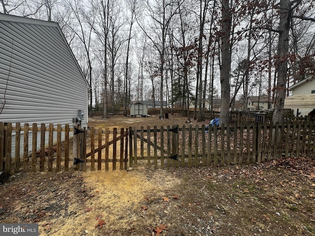 view of yard featuring an outbuilding, a storage unit, and fence