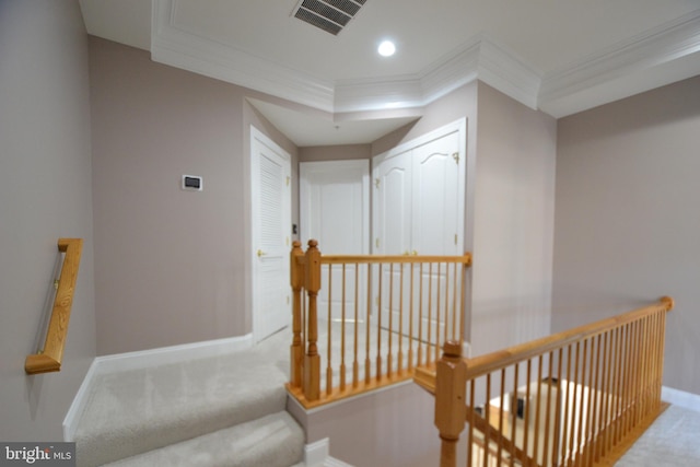 hallway featuring visible vents, baseboards, carpet floors, and ornamental molding