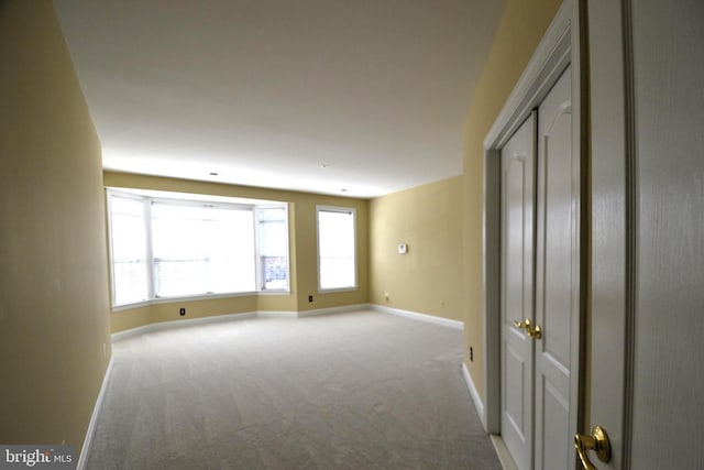 carpeted empty room featuring baseboards