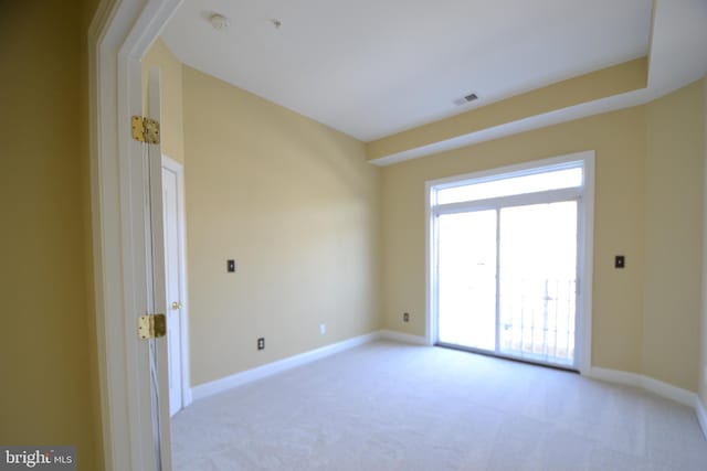 spare room with light colored carpet and baseboards