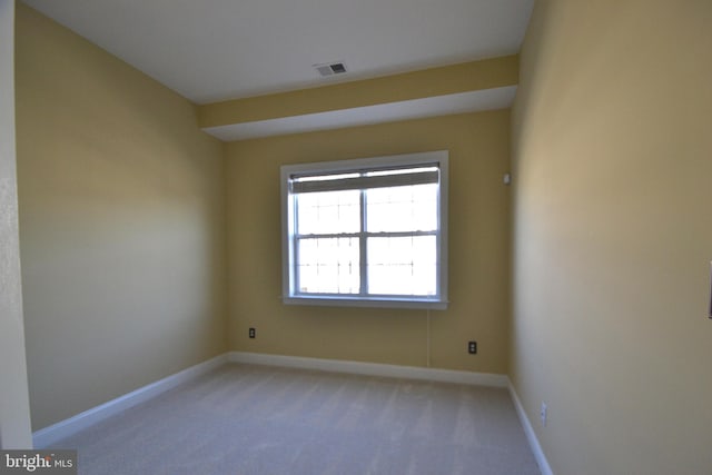 unfurnished room featuring visible vents, baseboards, and light colored carpet