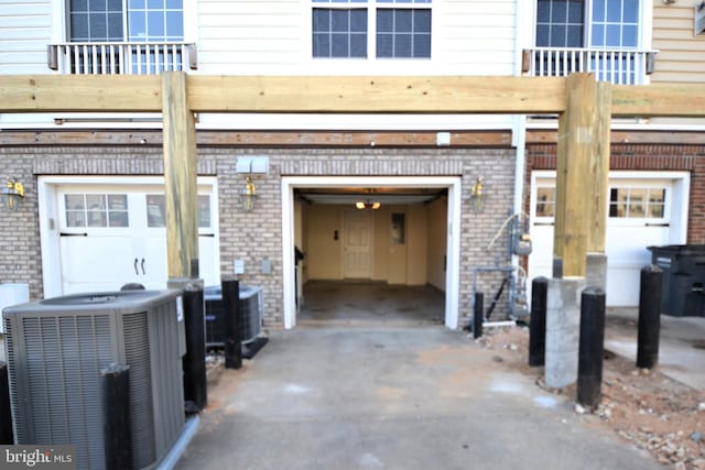 garage with central AC unit and concrete driveway