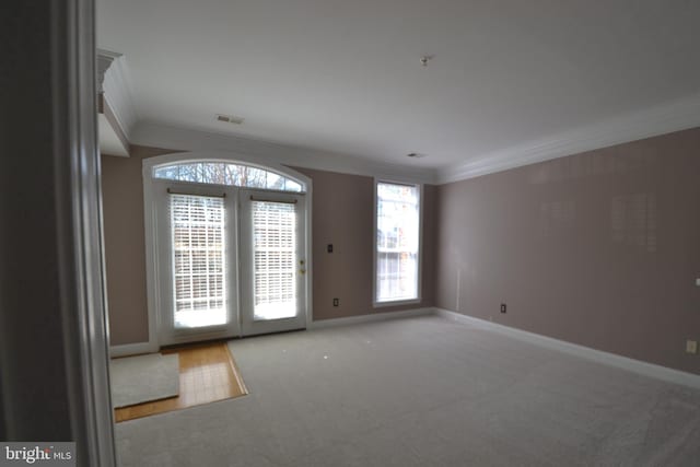 doorway to outside featuring visible vents, baseboards, carpet floors, and ornamental molding