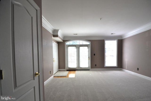 foyer entrance featuring light colored carpet, french doors, crown molding, and baseboards